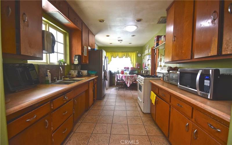 Large galley kitchen with eating area and access to yard.
