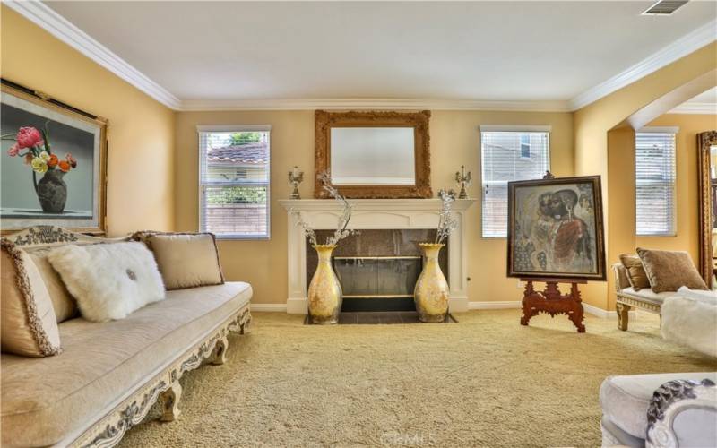 Spacious living room has fire place and crown molding.
