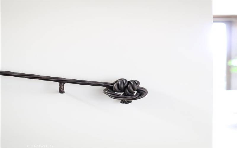 Custom, hand-crafted wrought-iron knot banister on staircase.