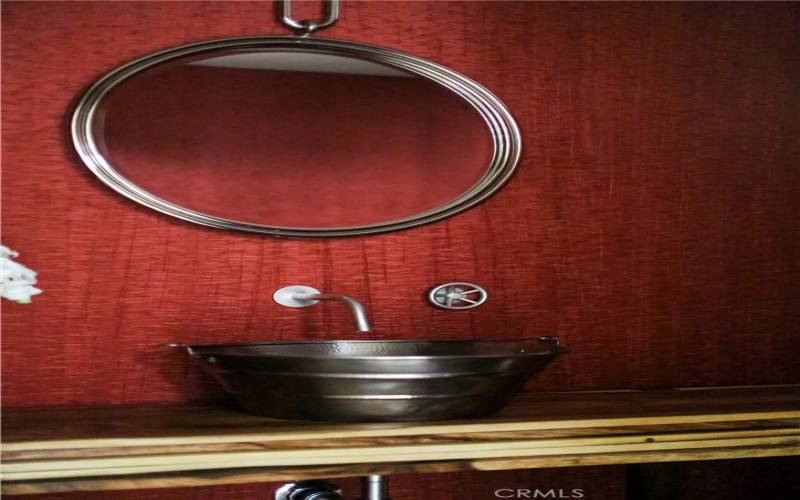 Stainless steel vessel sink with stylish exposed plumbing and custom details.