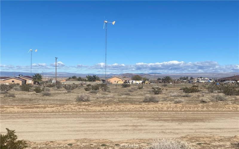 This photo was taken at the front lot line looking to the north across the street. Amazing view of mountains, custom homes and unpaved road appears maintained.