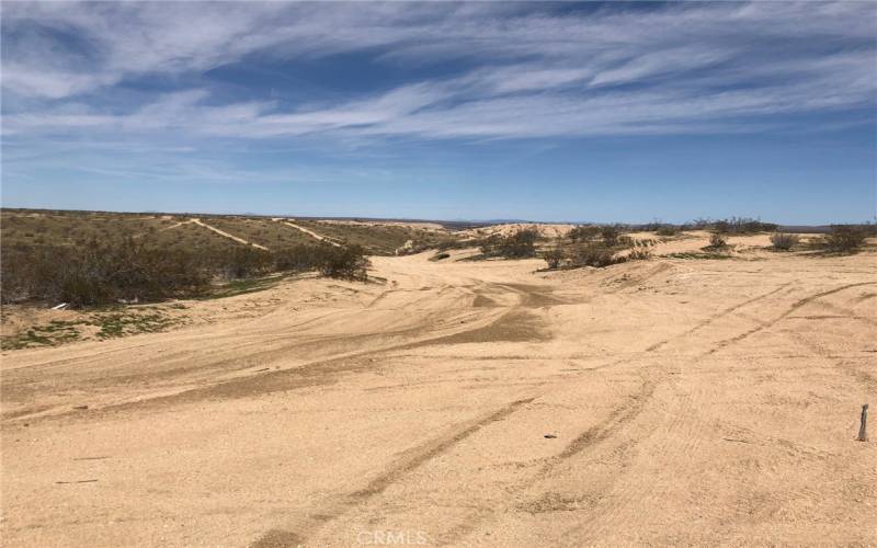 As you travel east on Morning Glory/Purple Sage it will end and you then will make a left going down a small hill. There is a burned out car on the left hand side that you will see.