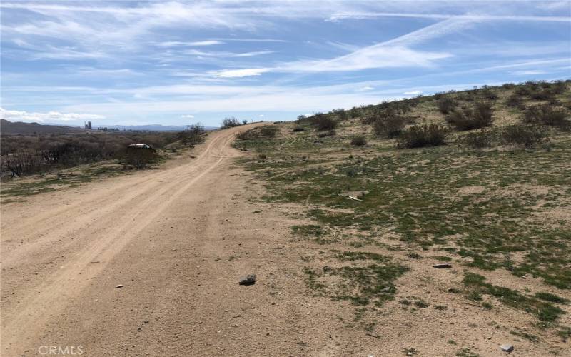 View is looking south. You can see an old car on the left hand side. If you pass that, you have gone to far.