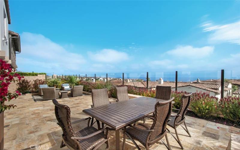 Spacious patio with dining table and firepit seating, plus 180 degree views of the ocean