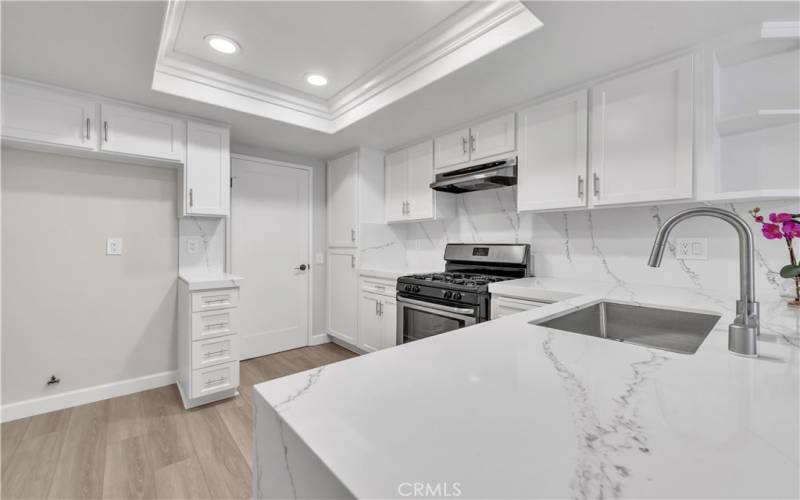 Newly Upgraded Kitchen with Modern White Cabinetry, Quartz Marble Countertops with Waterfall Design, Full Backsplash.  Upgraded Sink and New Faucet.