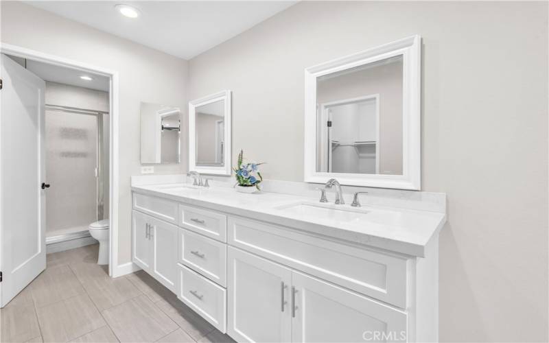 Primary Bedroom with Remodeled Ensuite Bath with Dual Wash Basins and Modern White Cabinets