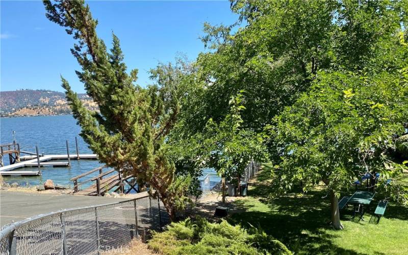 Shaded, Fenced picnic area by lake.