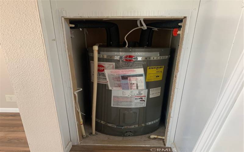 STRAPPED NEW HOT WATER HEATER IN MASTER BEDROOM CLOSET.