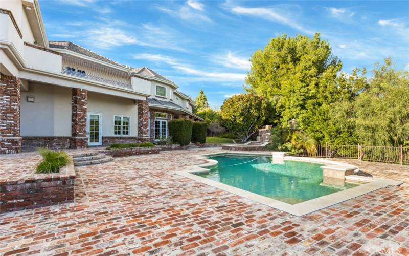 Entertainer’s backyard offers a custom barbecue and kitchen, entertainment pool/spa, large pool house with a full kitchen, lighted tennis court, all surrounded by beautiful horse property.