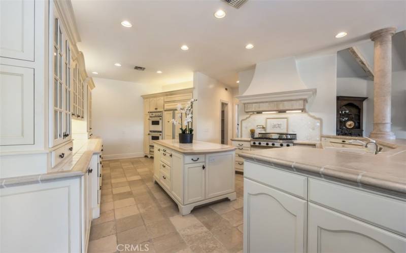 Gourmet kitchen with Viking appliances, Subzero refrigerator, center island, walk-in pantry, and butler pantry with dishwasher, sink, microwave, and coffee counter.