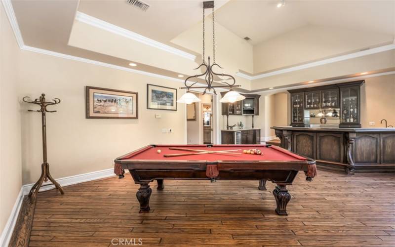Oversized game room with built-in cabinets and a custom built-in bar with seating for 8.