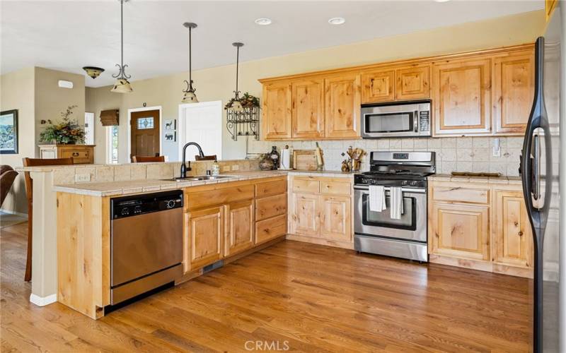 Well appointed kitchen with stone counter tops and pine cabinets