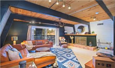 Spacious Livingroom W/Custom Gas Log or Wood Burning Fire Place. Slider leads out to Front Deck.