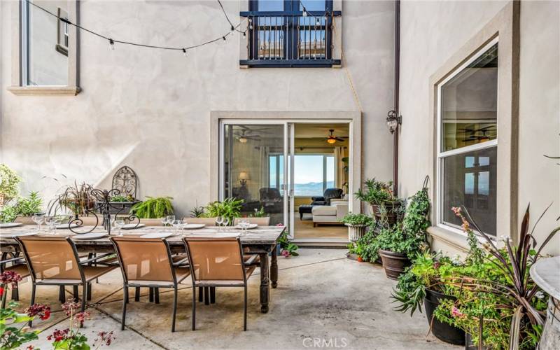 As you enter, the courtyard stands before you. Go left to the guest room and bath, go right to the kitchen and family room, or step right through the courtyard.