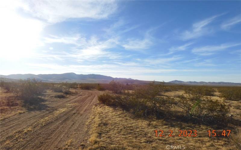 From Barstow Rd, showing where dirt road jogs to the left.  You can see the little building off to the right of the road.