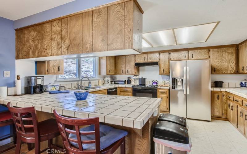 Generous-sized kitchen with eat-in breakfast bar. With plenty of cabinet space.