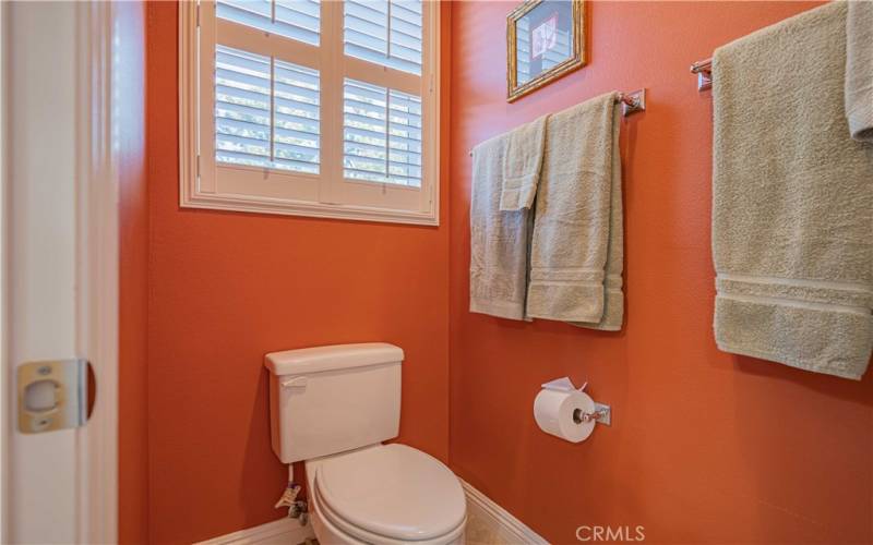 Seperate water closet room with window. Window has plantation shutters. Tiled flooring with white baseboard trim.