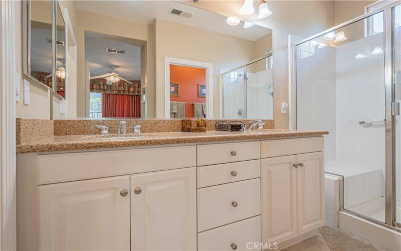 Dual white porcelian sinks with granite on top. Vanity matches the kitchen with the same cupboards with stainless steel hardware. Walk-in shower and seperate toilet room.