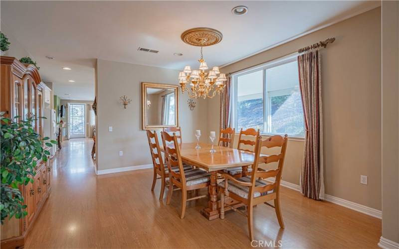 Hardwood oak engineered flooring with recessed lighting above, a chandelier, window that looks onto uour massive alumawood patio area, and dining room table/chairs  that  are staying!