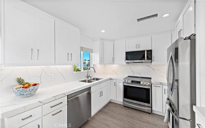 KITCHEN OVERLOOKS GOFF ISLAND AND INCLUDES STAINLESS STEEL APPLIANCES AND QUARTZ COUNTER TOPS