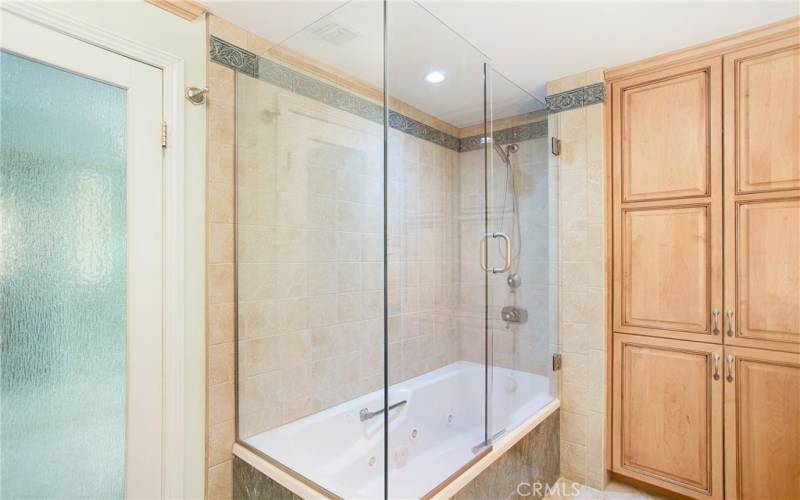 Shower and tub with loads of storage in one of the primary suites.