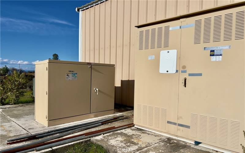 3 Phase Electrical Power Cabinets behind Large Steel Shop.