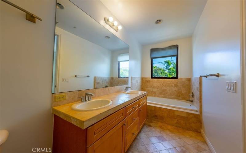 Master bath with double sink and view of tree tops