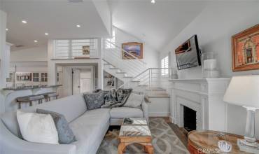 Living room open to kitchen with steps leading to primary suite & upstairs deck with views...