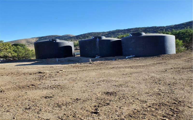 Three 3,000 gallon water tanks.  Located at Upper end of lot.  Connected to an irrigation system.