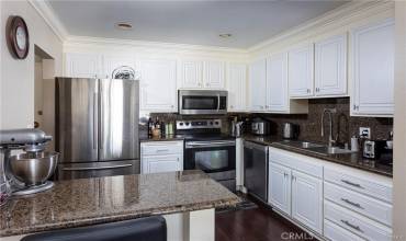 The kitchen which features granite counter tops, stainless steel appliances, and a breakfast bar.