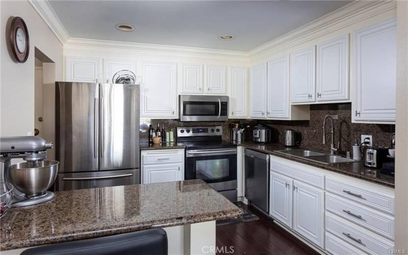 The kitchen with features granite counter tops, stainless steel appliances, and a breakfast bar.