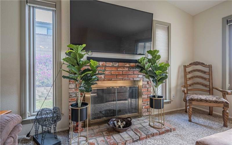Family room has a cozy fireplace that has windows on both sides with pull down shades. These windows allow for more natural light to enter the family room and view the back yard.