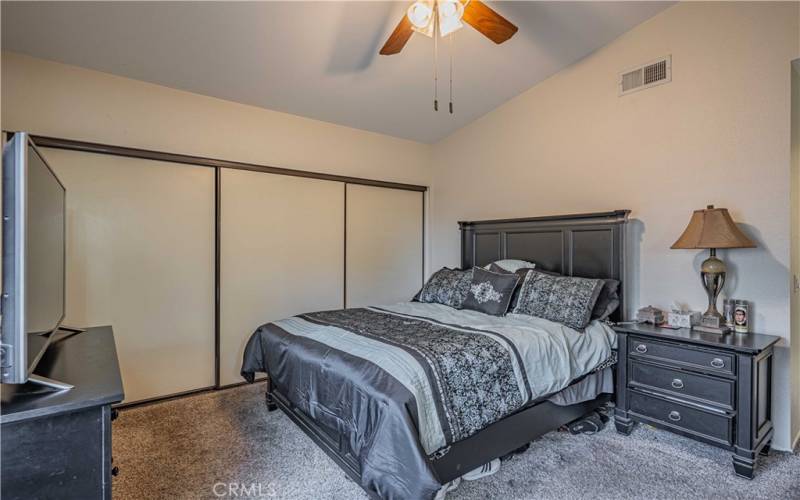 Primary bedroom is carpeted witth ceiling fan. Large sliding closet. This room also has a door to outside, and a primary en-suite bathroom.