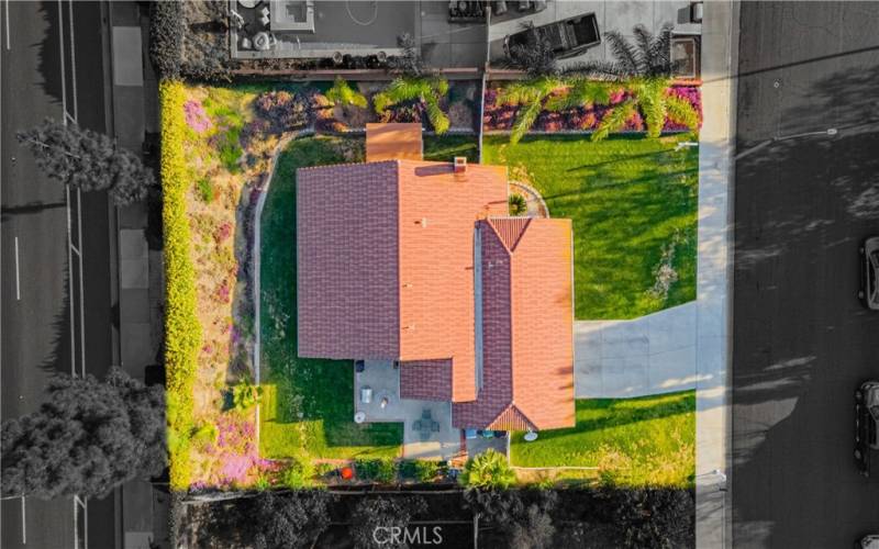 Drone photo allows you to see you have RV parking capability. Grass area trims the front and back yards. Concrete area for entertaining on one side of the home, and the other side has a patio area.