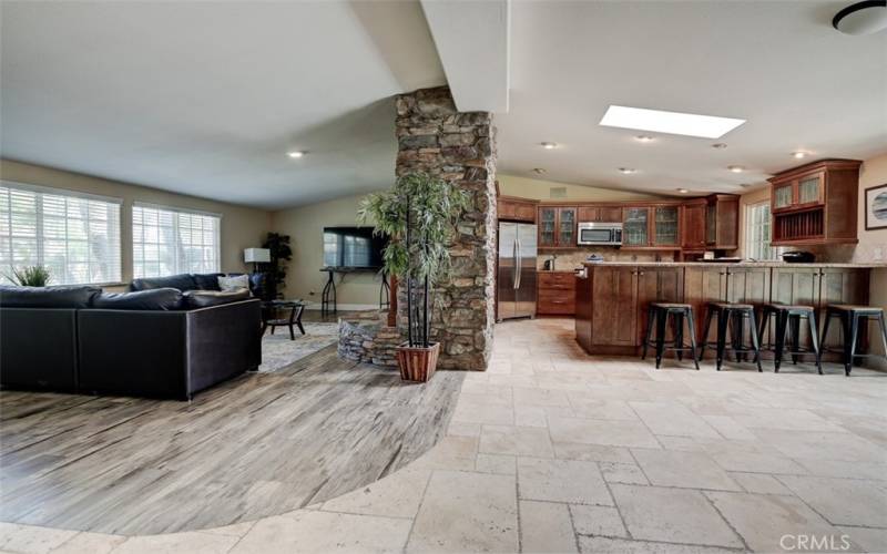 Open-concept floorplan separated by rock​​‌​​​​‌​​‌‌​​‌​​​‌‌​​​‌​​‌‌​​‌‌​​‌‌​​​​ fireplace.