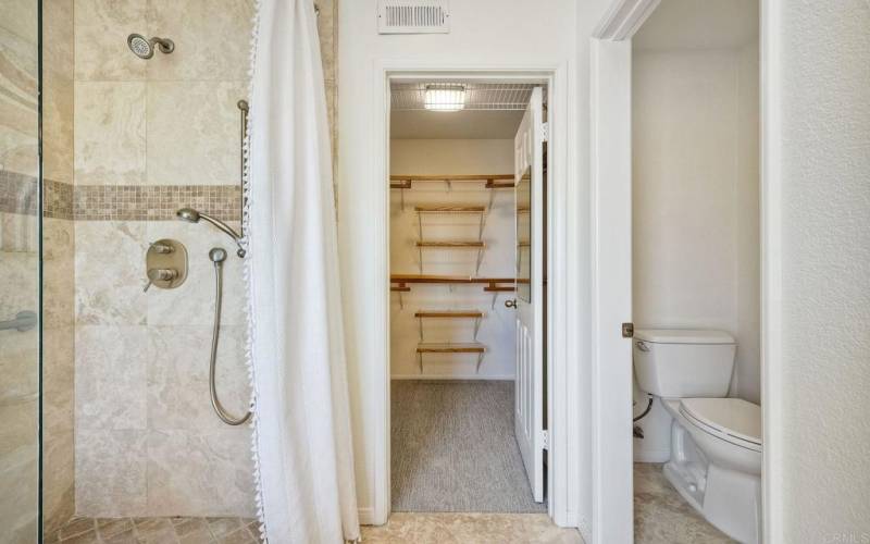 Primary bathroom natural stone shower and large walk-in closet.
