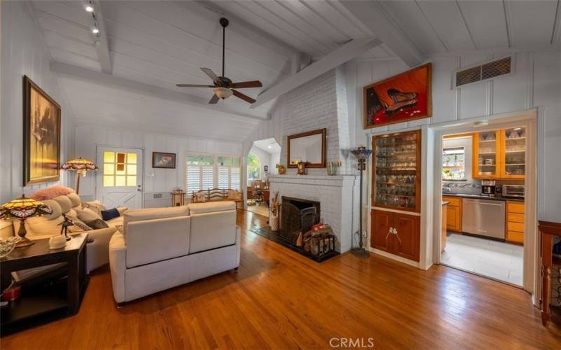 Living room with high vaulted beam ceiling, genuine hardwood floors, plantation shutters and a lot of cha
