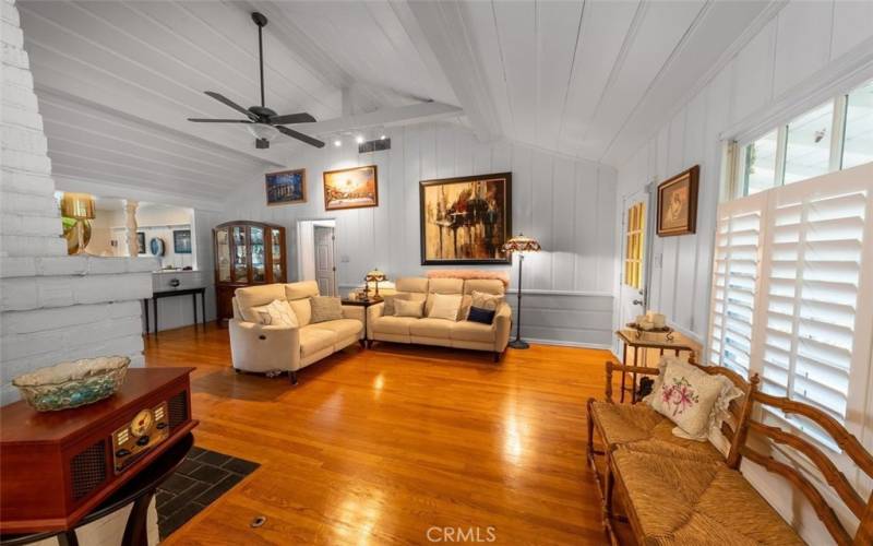 Living room with high vaulted beam ceiling, genuine hardwood floors, plantation shutters and a lot of character.