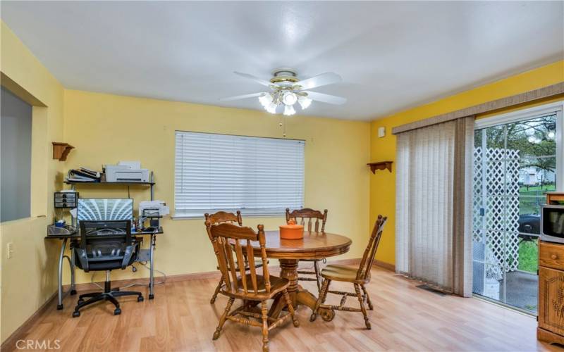 Large dining area with laminate floors and sliding door to back patio.