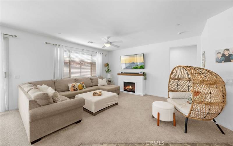 Living area showing window blinds and ceiling fan. Sellers are taking the portable fireplace