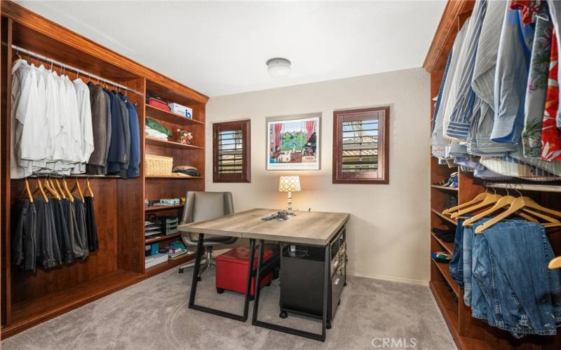Primary bedroom closet with custom built-ins offers so much space, it's currently used as an office as well!