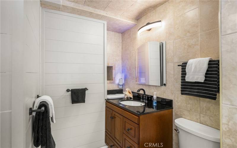 Ensuite bath for third bedroom features modern lighting and plenty of space for towels!