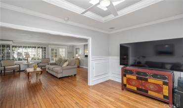 Enclosed atrium with open skylight and ceiling fan, designer wainscoting on walls