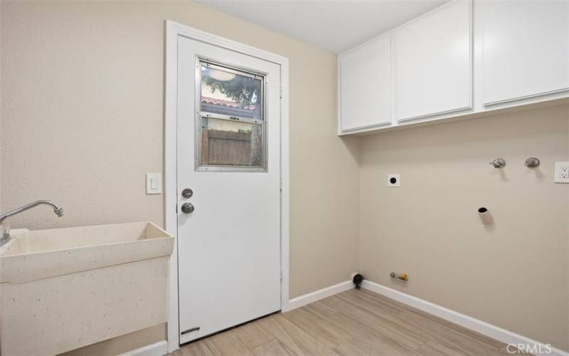 Laundry room with washtub and back door.