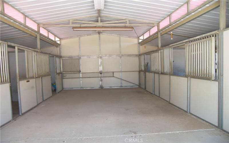 Barn interior with 4 stalls and tack room.