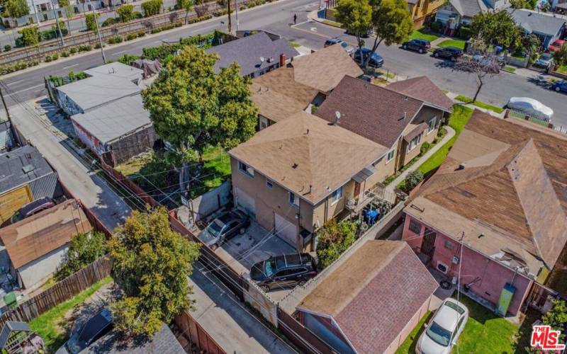 rear aerial of front home and single car parking garages