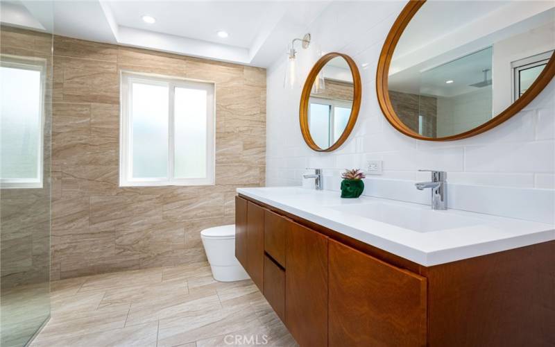 En-suite primary bathroom, newly renovated with contemporary and luxury finishings including dual rain shower head and hand shower.