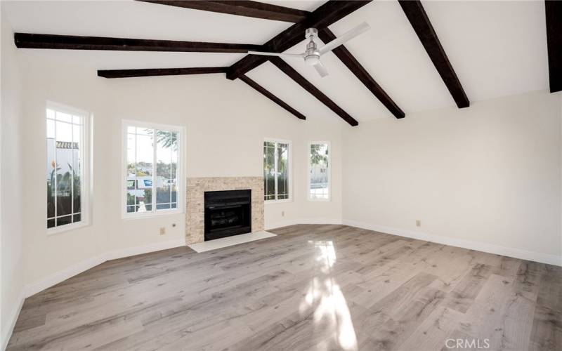 Family room with vaulted ceilings, fireplace and new flooring