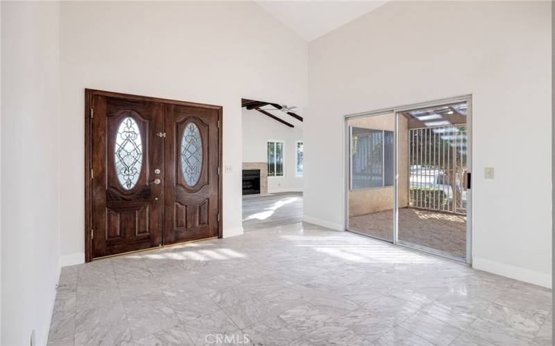 Entryway with vaulted ceilings and marble flooring