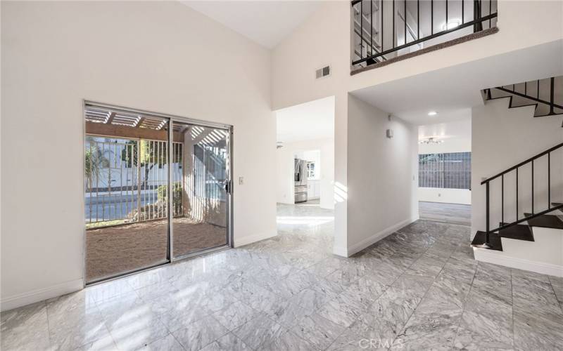 Entryway with high vaulted ceilings and marble flooring. Outdoor enclosed area between family room and dining room